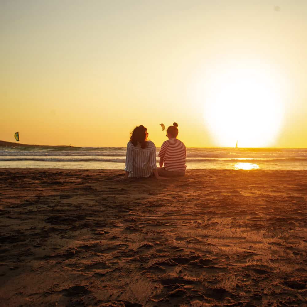 Women enjoying the ocean breeze on a sunny shore, representing healing and renewal through a Detox Program in Huntington Beach