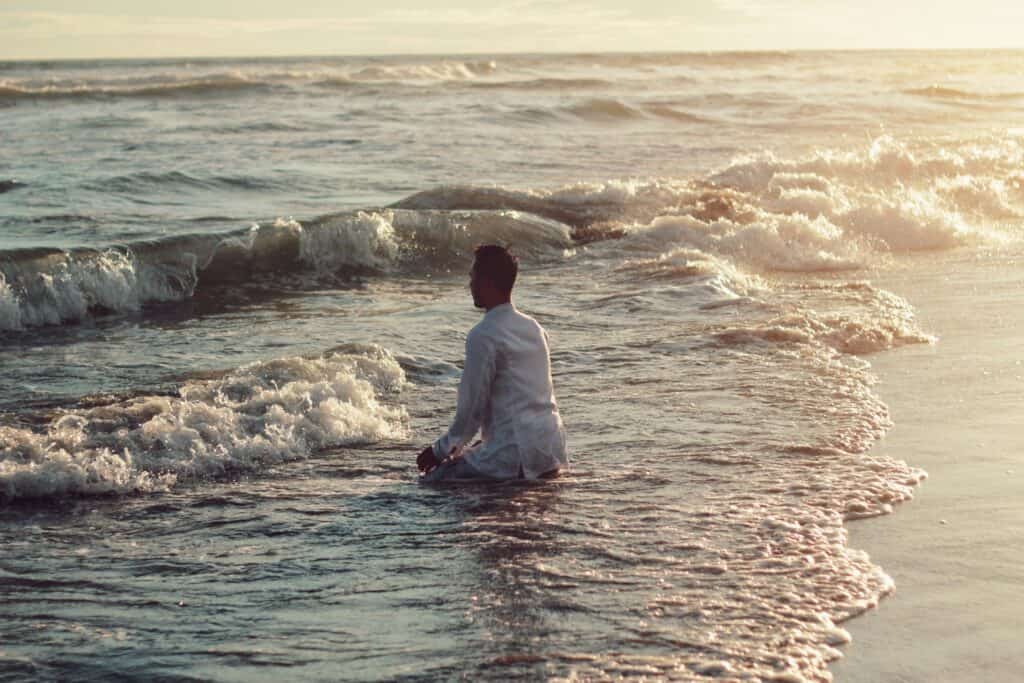 Man sitting on the shore, symbolizing reflection and healing during his experience with Drug Rehab in Huntington Beach