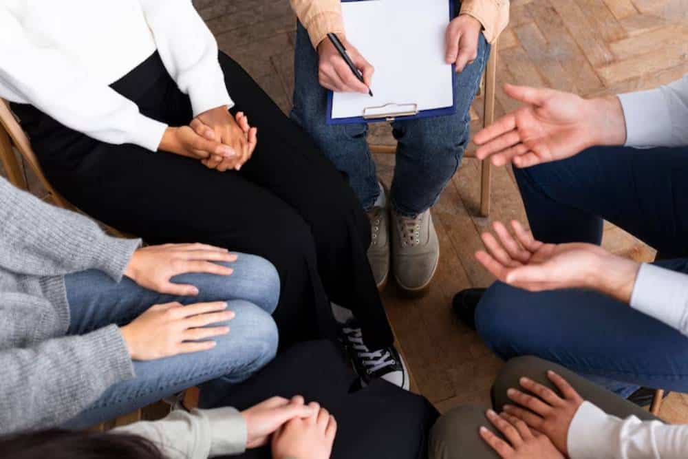 A support group in session, engaging in guided discussion during Opioid Addiction Treatment in Huntington Beach CA.