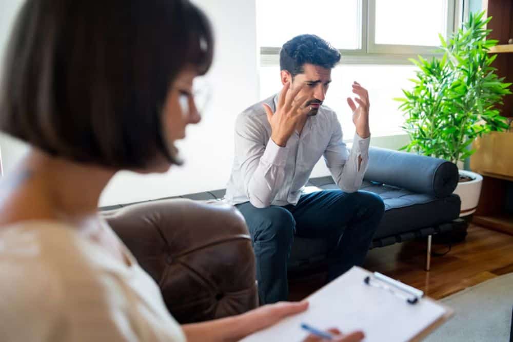 A man engages in an emotional therapy session, receiving professional support at a Huntington Beach alcohol rehab center.