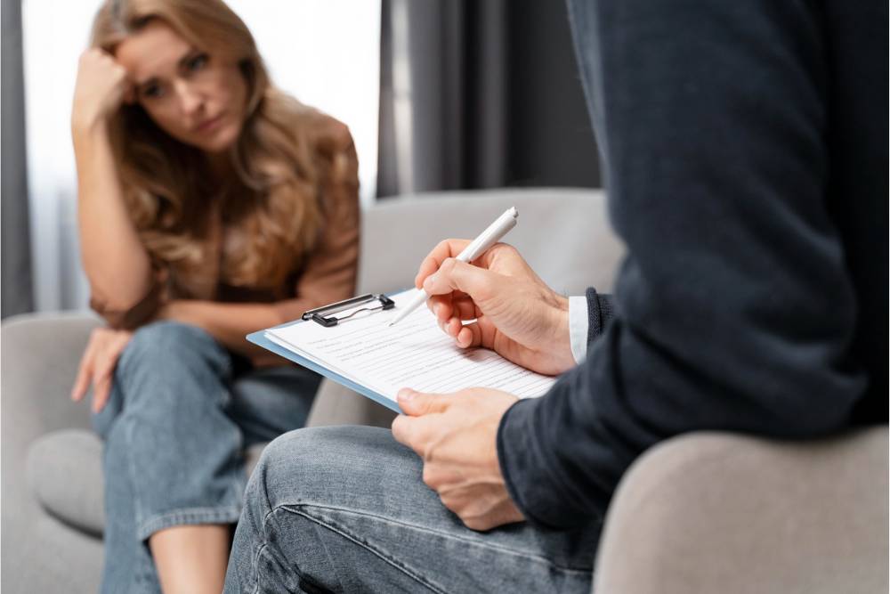 Therapist taking notes during a counseling session with a concerned woman, showing the supportive care available for meth addiction treatment in Huntington Beach, CA.
