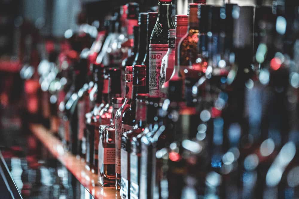 Close-up of liquor bottles symbolizing addiction triggers and the first step toward healing through Alcohol Detox in Huntington Beach.